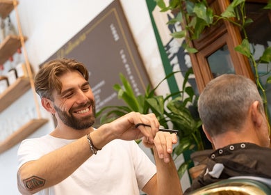 Friendly stylist at Porem Damsquare, Amsterdam, Noord-Holland, NL, skillfully cutting a client's hair.