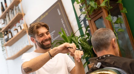 Friendly stylist at Porem Damsquare, Amsterdam, Noord-Holland, NL, skillfully cutting a client's hair.