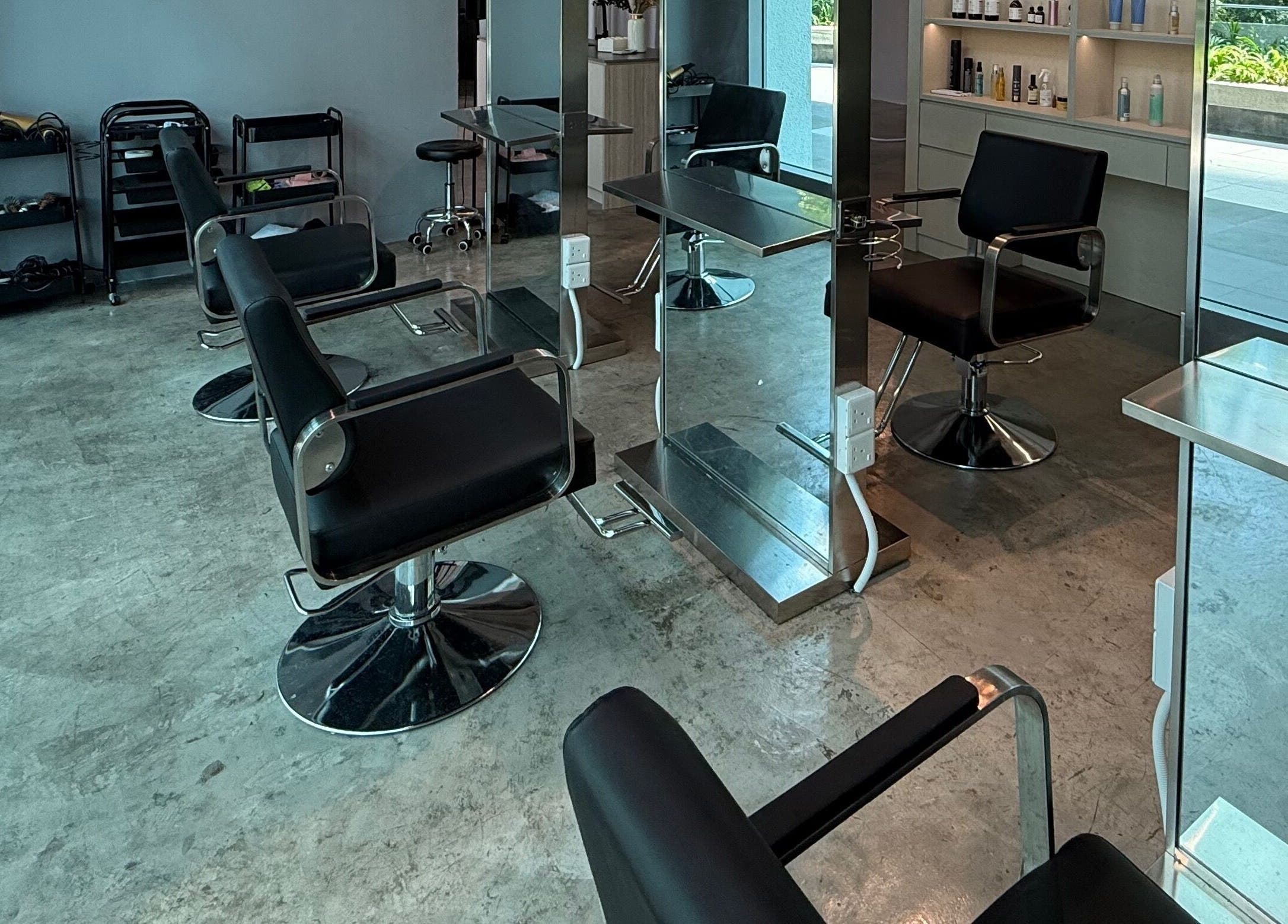 Modern interior of Layers Hair Salon in Kuala Lumpur, featuring sleek styling chairs and mirrors.