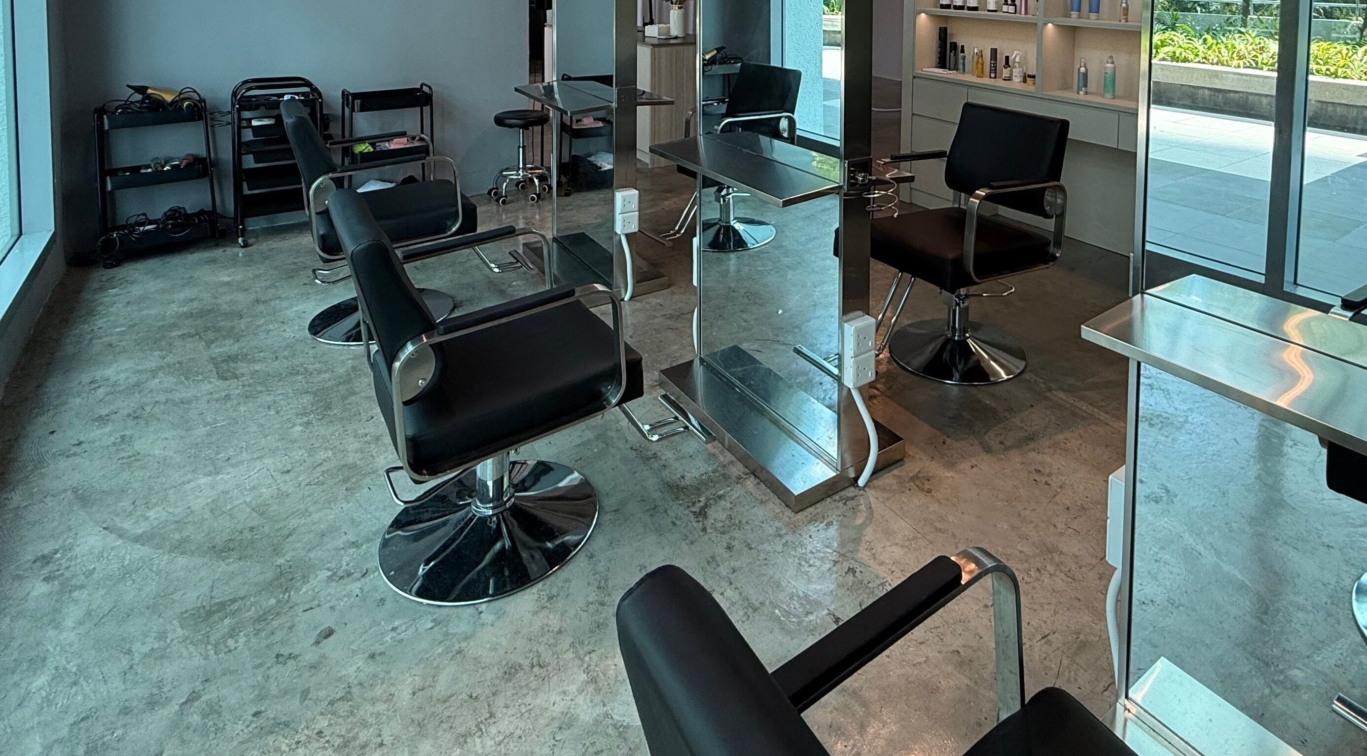 Modern interior of Layers Hair Salon in Kuala Lumpur, featuring sleek styling chairs and mirrors.