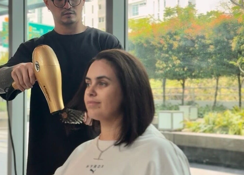 Stylist blow-drying hair at Layers Hair Salon in Kuala Lumpur, Wilayah Persekutuan Kuala Lumpur, MY.