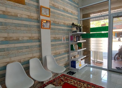 Interior ruang tunggu Bathin Center Terapy di Kepulauan Riau dengan kursi putih dan rak buku.