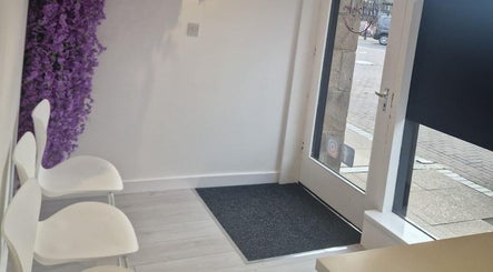 Inviting entryway at Skin By Shannon, Tranent, Scotland, GB with white chairs and purple flower decor.