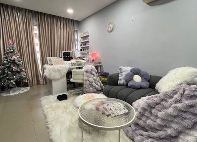 Killynails' relaxing lounge in Singapore, SG with plush furniture and nail care setup beside Christmas decor.