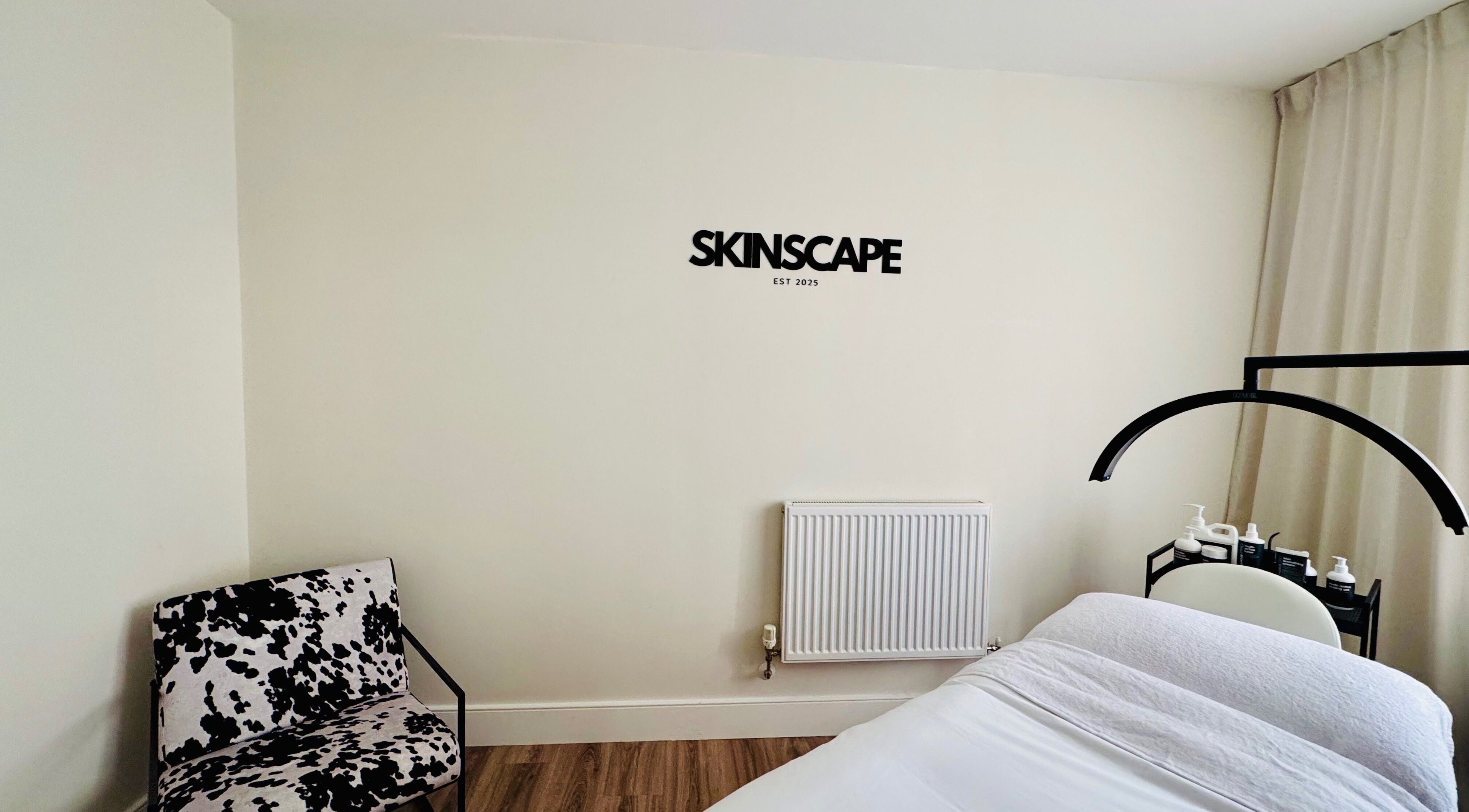 Calm treatment room at Skinscape Bristol, a wellness venue in Bristol, England, GB, featuring a white massage bed.