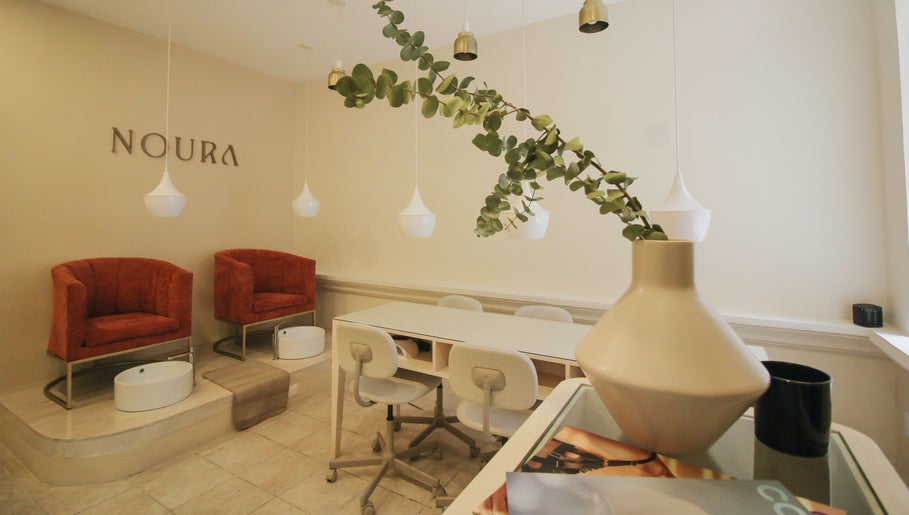 Interior elegante de Noura Nails Boutique, Ciudad De México, con sillas de lujo y decoración moderna.