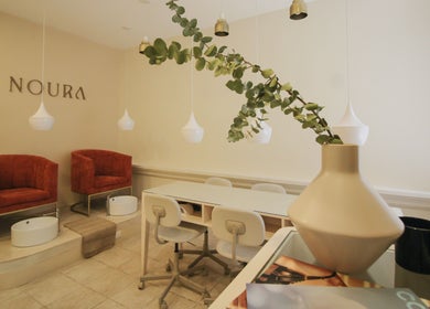 Interior elegante de Noura Nails Boutique, Ciudad De México, con sillas de lujo y decoración moderna.