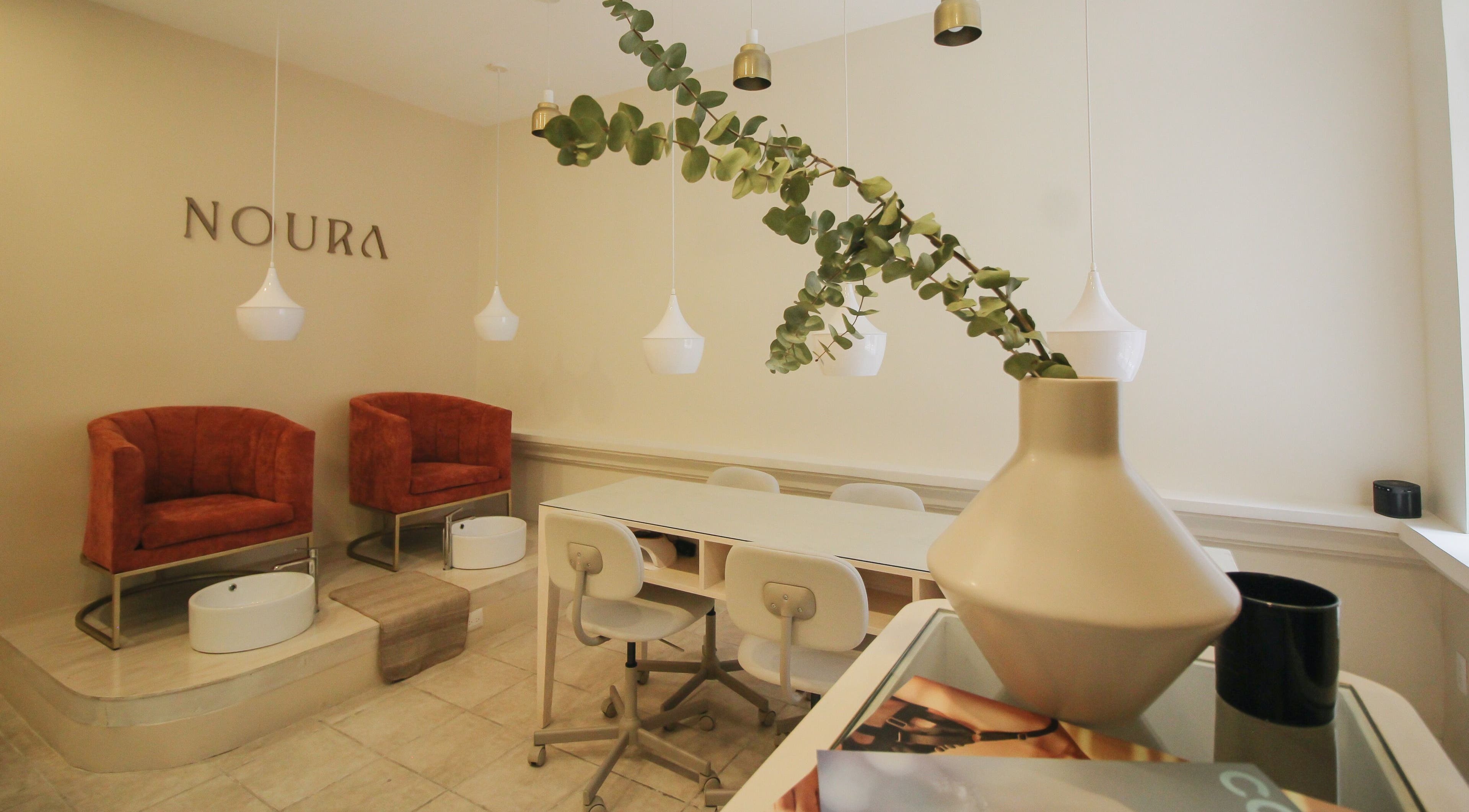 Interior elegante de Noura Nails Boutique, Ciudad De México, con sillas de lujo y decoración moderna.