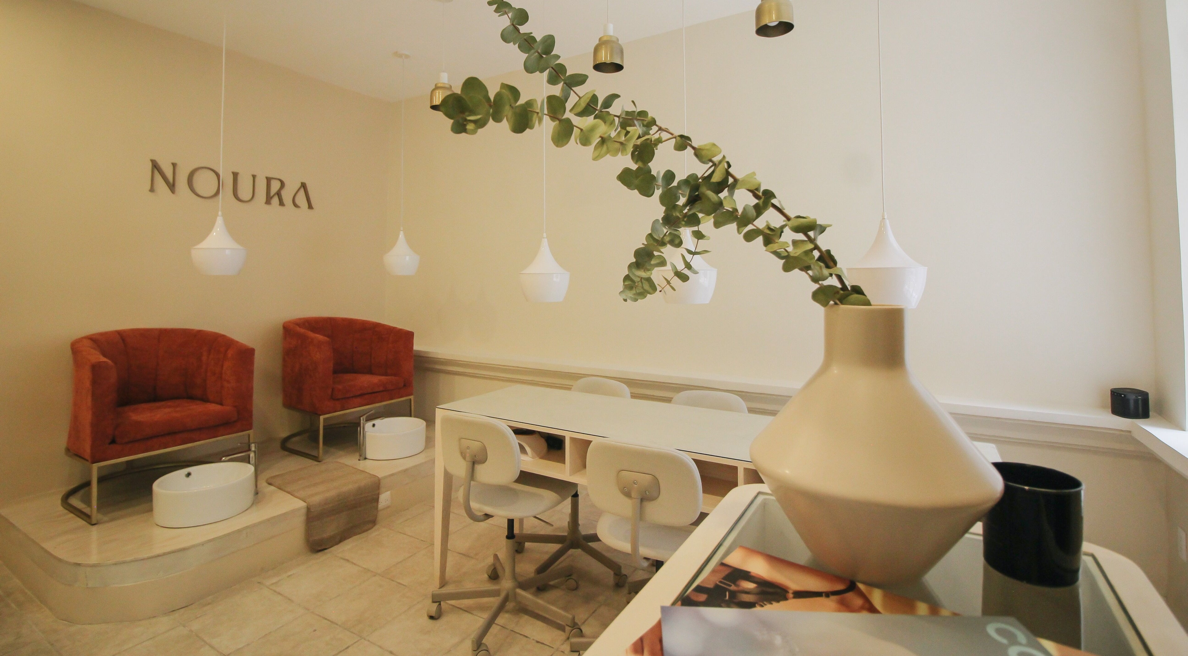 Interior elegante de Noura Nails Boutique, Ciudad De México, con sillas de lujo y decoración moderna.
