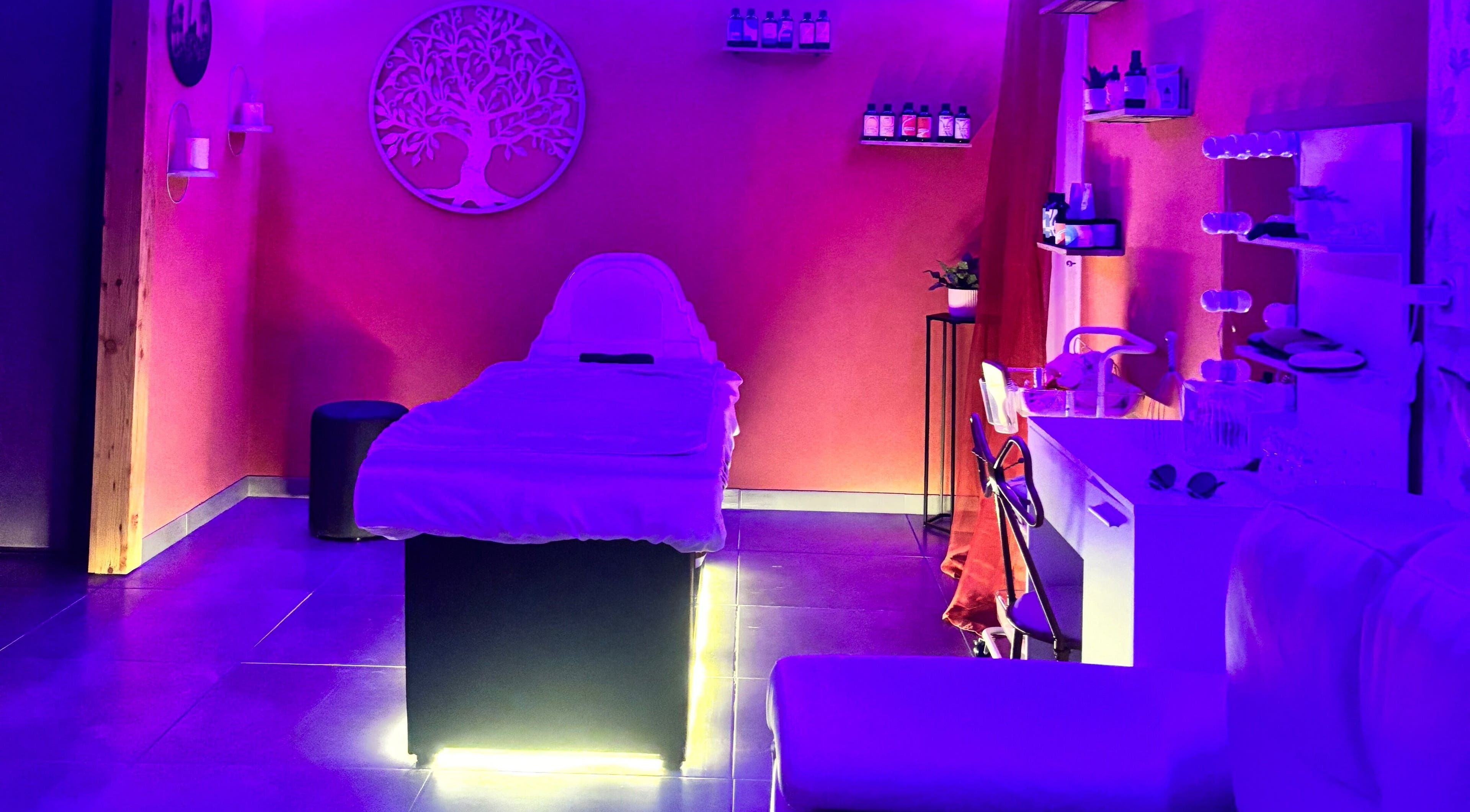 Salle de soin apaisante à Kalm Headspa, Vecoux, Grand Est, FR, avec éclairage violet relaxant.