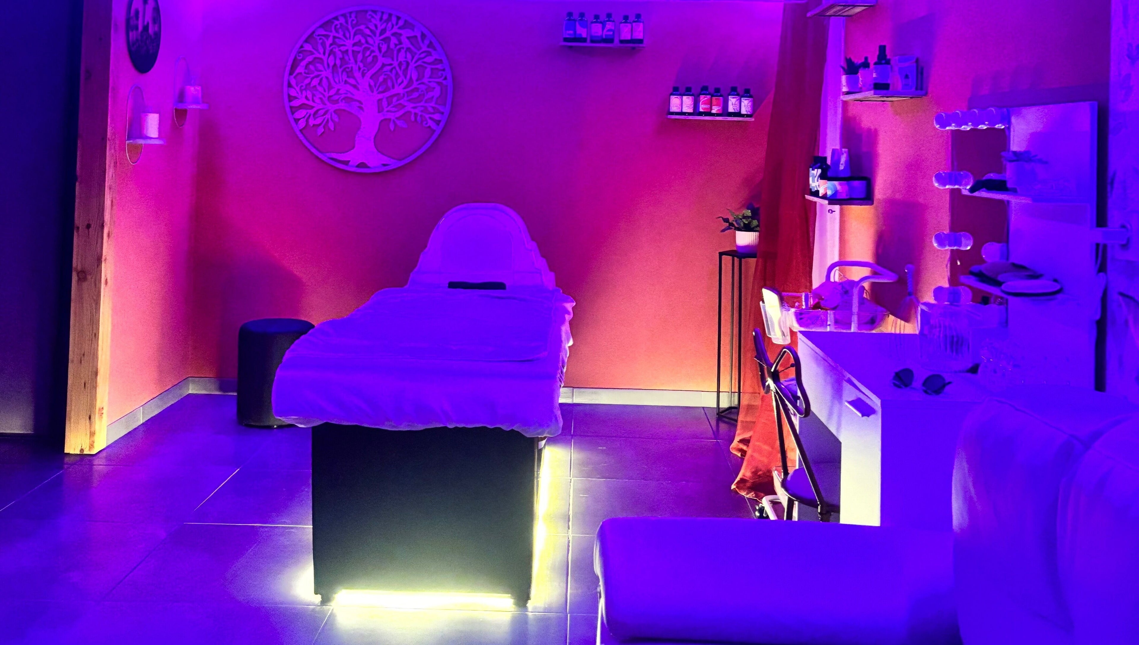 Salle de soin apaisante chez Kalm Headspa, Vecoux, Grand Est, FR avec éclairage doux et table de massage.