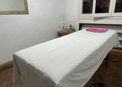 Sala de masajes en Gio’s Beauty en Salta, Salta, AR, con una camilla blanca y toalla rosa.