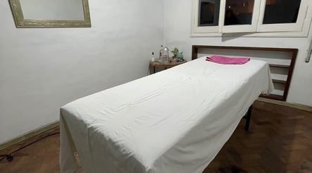 Sala de masajes en Gio’s Beauty en Salta, Salta, AR, con una camilla blanca y toalla rosa.