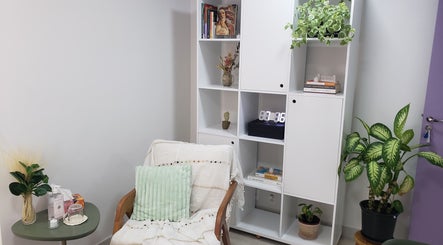 Espaço acolhedor no Favo Coworking de Saúde, São Paulo, SP, com poltrona, plantas e estante moderna.