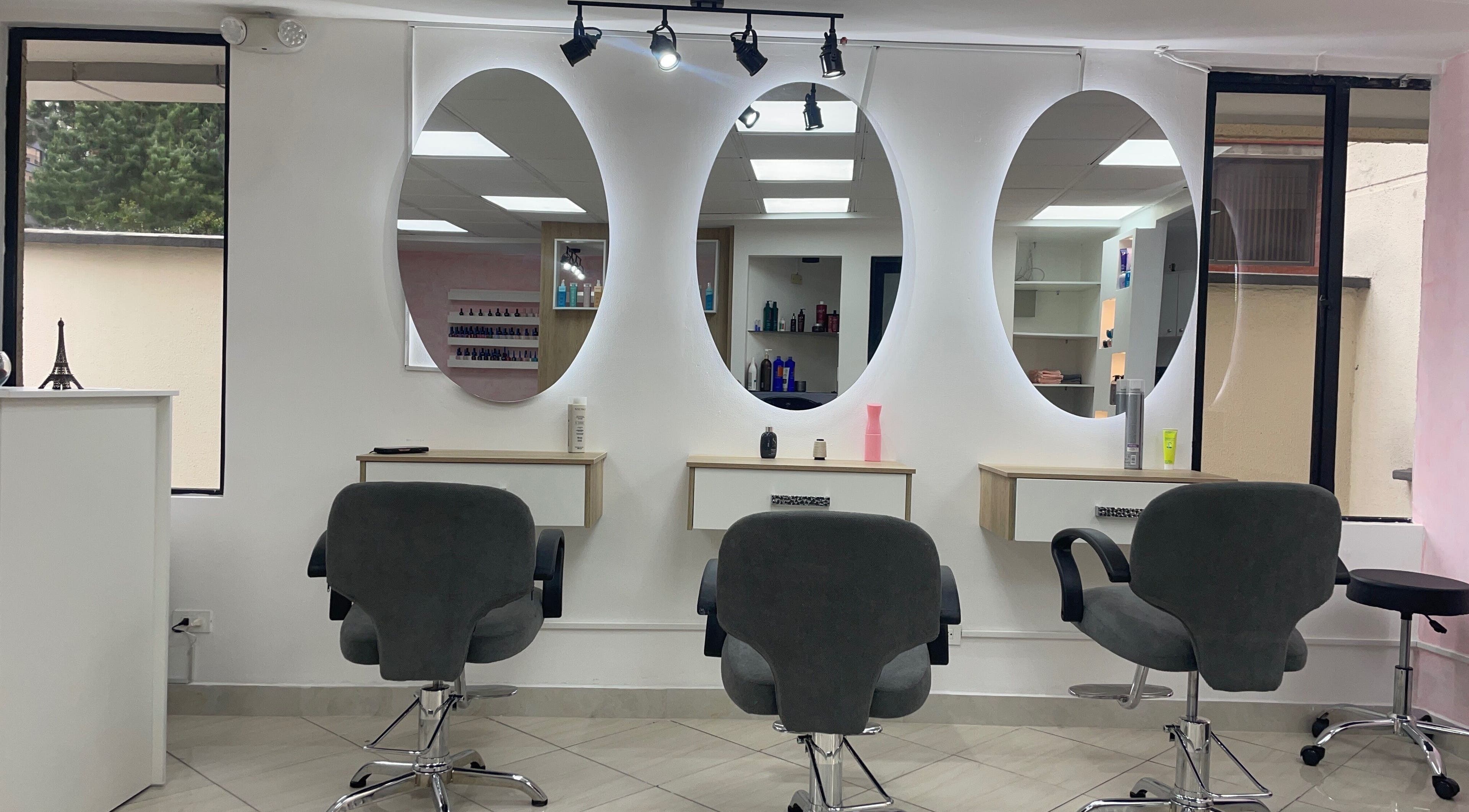 Interior moderno de Warmi Beauty Studio en Quito, Pichincha, EC con espejos ovalados y sillas de estilista.