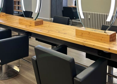 Moderner Salonbereich bei LucaHair, Düsseldorf, Nordrhein-westfalen, DE. Stilvolle Spiegel und bequeme Stühle.