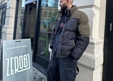 Outside Mens Haircut Windsor by Ritzy’s in Windsor, England, GB. A man stands by the hair studio entrance.