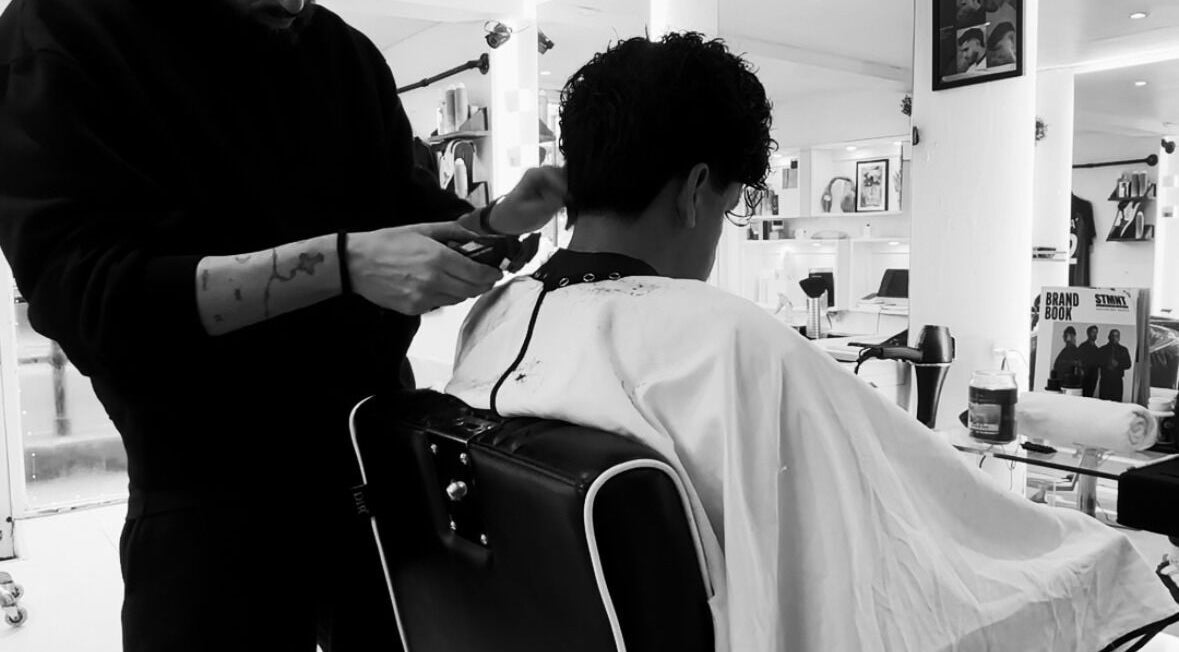 Stylist performing a mens haircut at Ritzy’s, Windsor, England, GB. Modern salon interior.