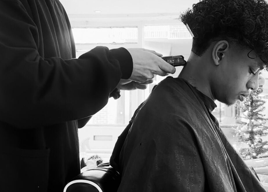 A stylist trims a man's hair at Mens Haircut Windsor by Ritzy’s, Windsor, England, GB.