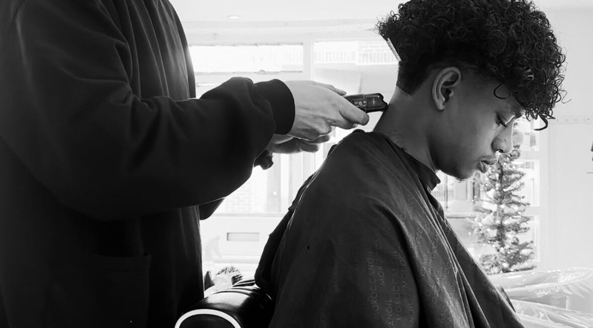 A stylist trims a man's hair at Mens Haircut Windsor by Ritzy’s, Windsor, England, GB.
