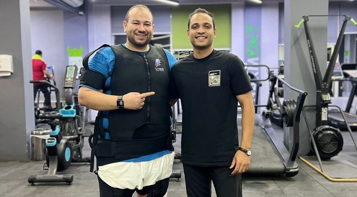Two smiling men at Abdallah gym, محافظة القاهرة‬, محافظة القاهرة‬, EG, in a modern fitness environment.