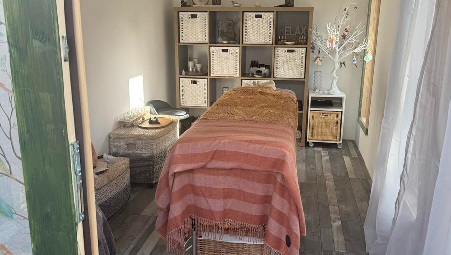 Serene spa room at Amethyst Touch, Poole, England, GB featuring a cozy massage table and calming decor.