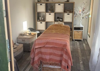 Serene spa room at Amethyst Touch, Poole, England, GB featuring a cozy massage table and calming decor.
