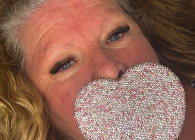 Close-up of a woman with glamorous lashes holding a sparkling heart at Lashed By Lucy, Farnham, England, GB.