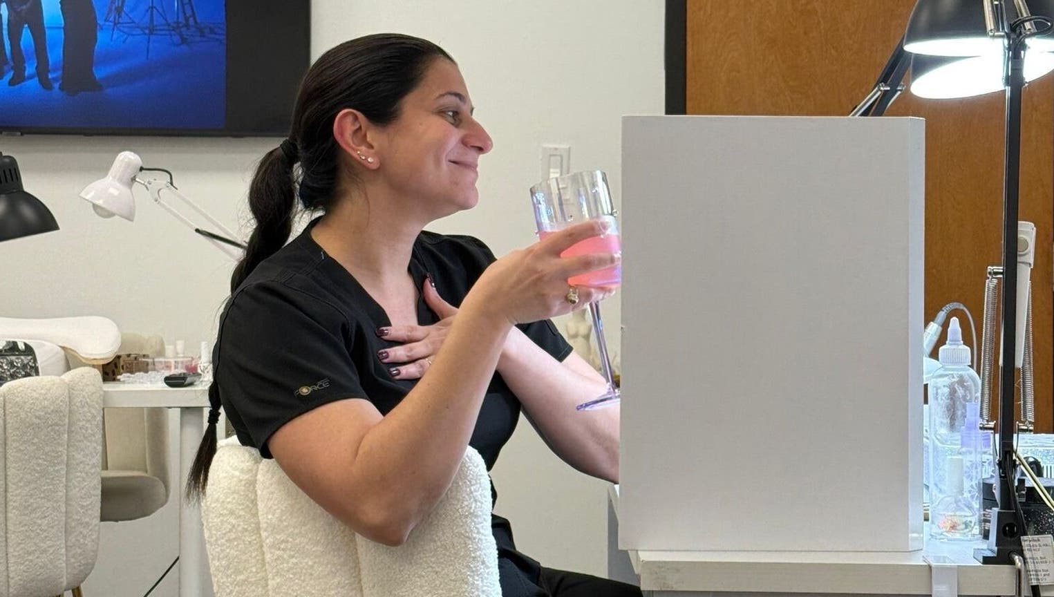 Cliente disfrutando en Nailsbyenifer, Memphis, Tennessee, US, con bebida rosa en mano.