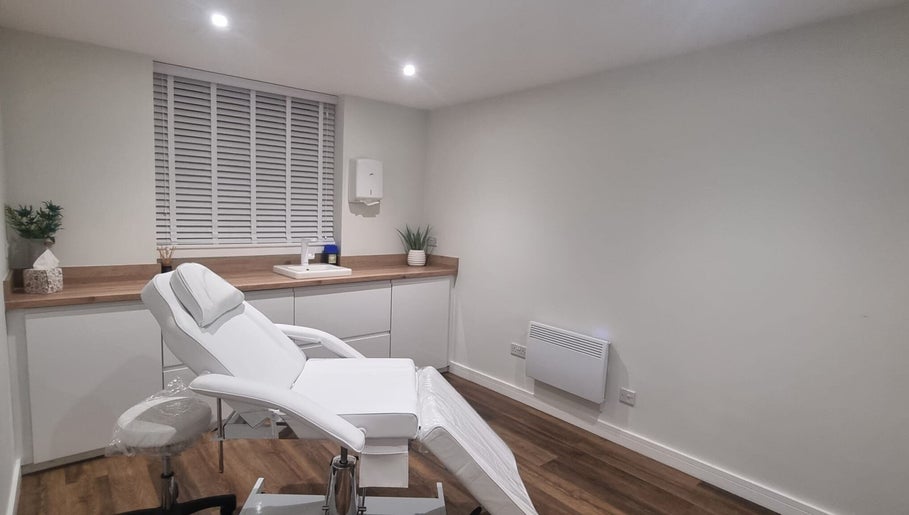 Modern treatment room at Enhance With Claire in Dunfermline, Scotland, GB, featuring a sleek white chair.