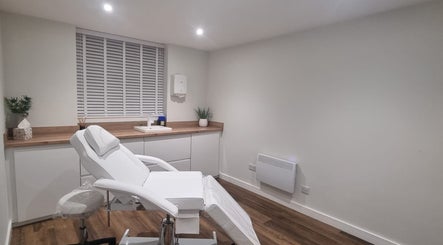 Modern treatment room at Enhance With Claire in Dunfermline, Scotland, GB, featuring a sleek white chair.
