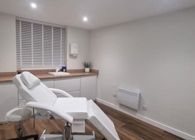 Calm treatment room at Enhance With Claire in Dunfermline, Scotland, GB featuring a white reclining chair.