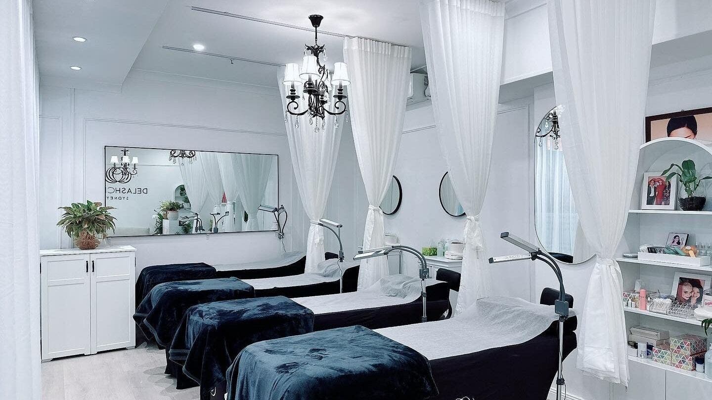 Chic interior of DE LASH MOSMAN in Mosman, New South Wales, AU with elegant spa beds and white curtains.