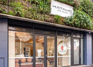 Exterior of Katamo Hair Salon in Melbourne, Victoria, AU with lush greenery and modern glass facade.