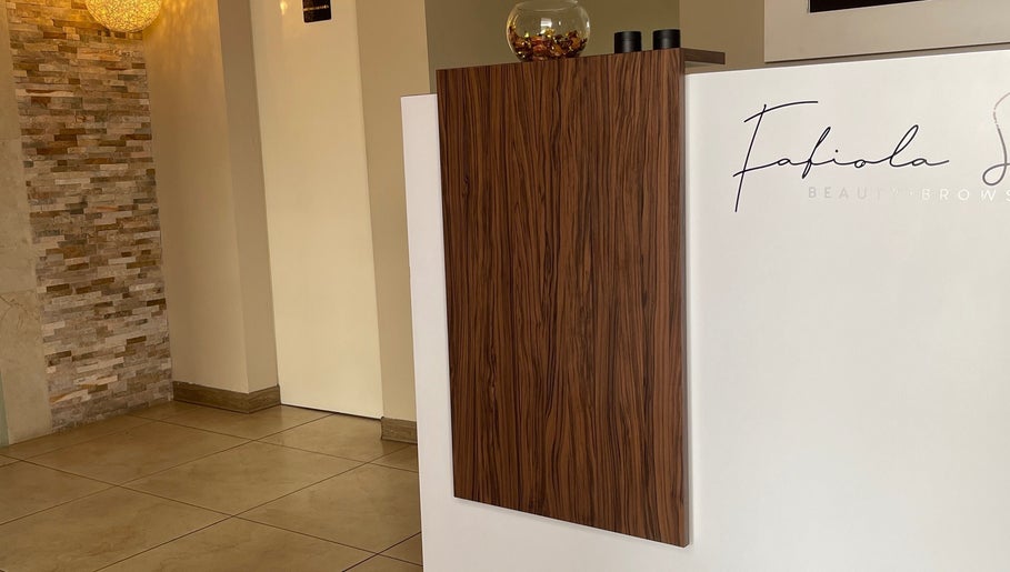 Recepción moderna en Estética Méndez, San José, San José, CR, con pared de piedra y decoración elegante.
