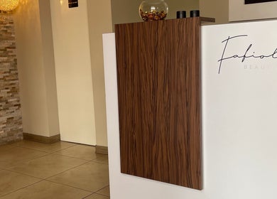 Recepción moderna en Estética Méndez, San José, San José, CR, con pared de piedra y decoración elegante.