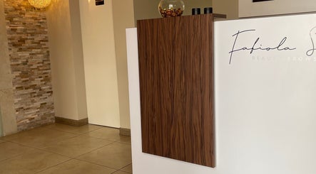 Recepción moderna en Estética Méndez, San José, San José, CR, con pared de piedra y decoración elegante.