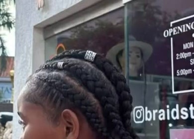Stylish braids showcased at Braids To Go, Noord, AW, with opening hours displayed in the background.