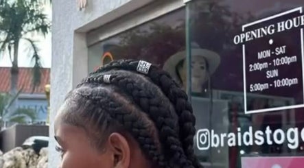 Stylish braids showcased at Braids To Go, Noord, AW, with opening hours displayed in the background.