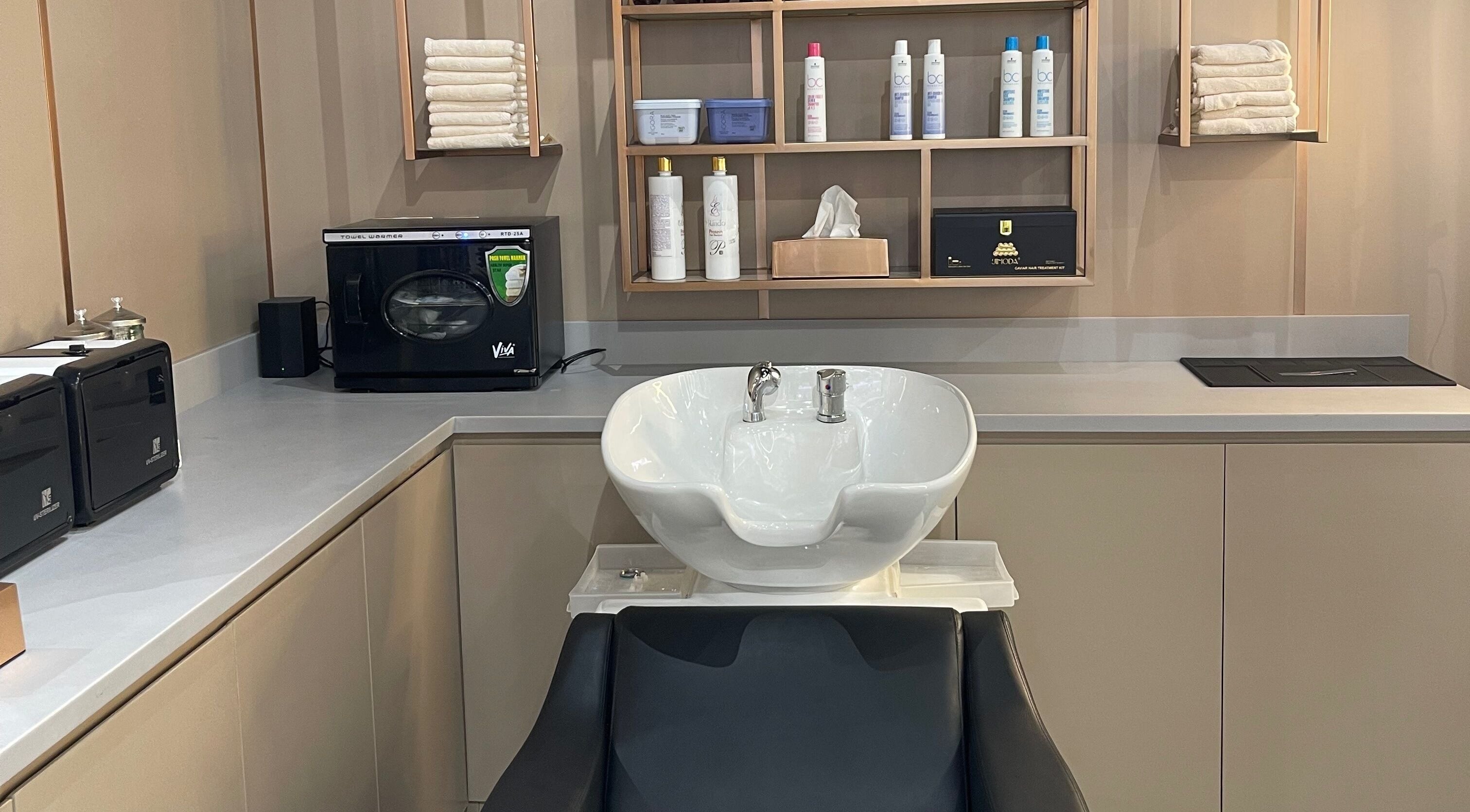 Modern hair wash station at Estilo Urbano Gents Salon, Umm Al Quwain, AE, showing sleek sink and products.