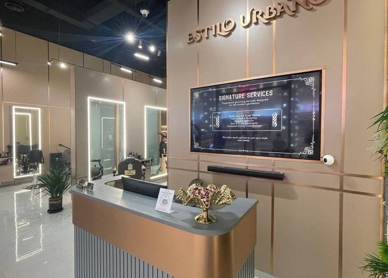 Chic interior of Estilo Urbano Gents Salon in Umm Al Quwain, AE featuring modern styling stations and greenery.