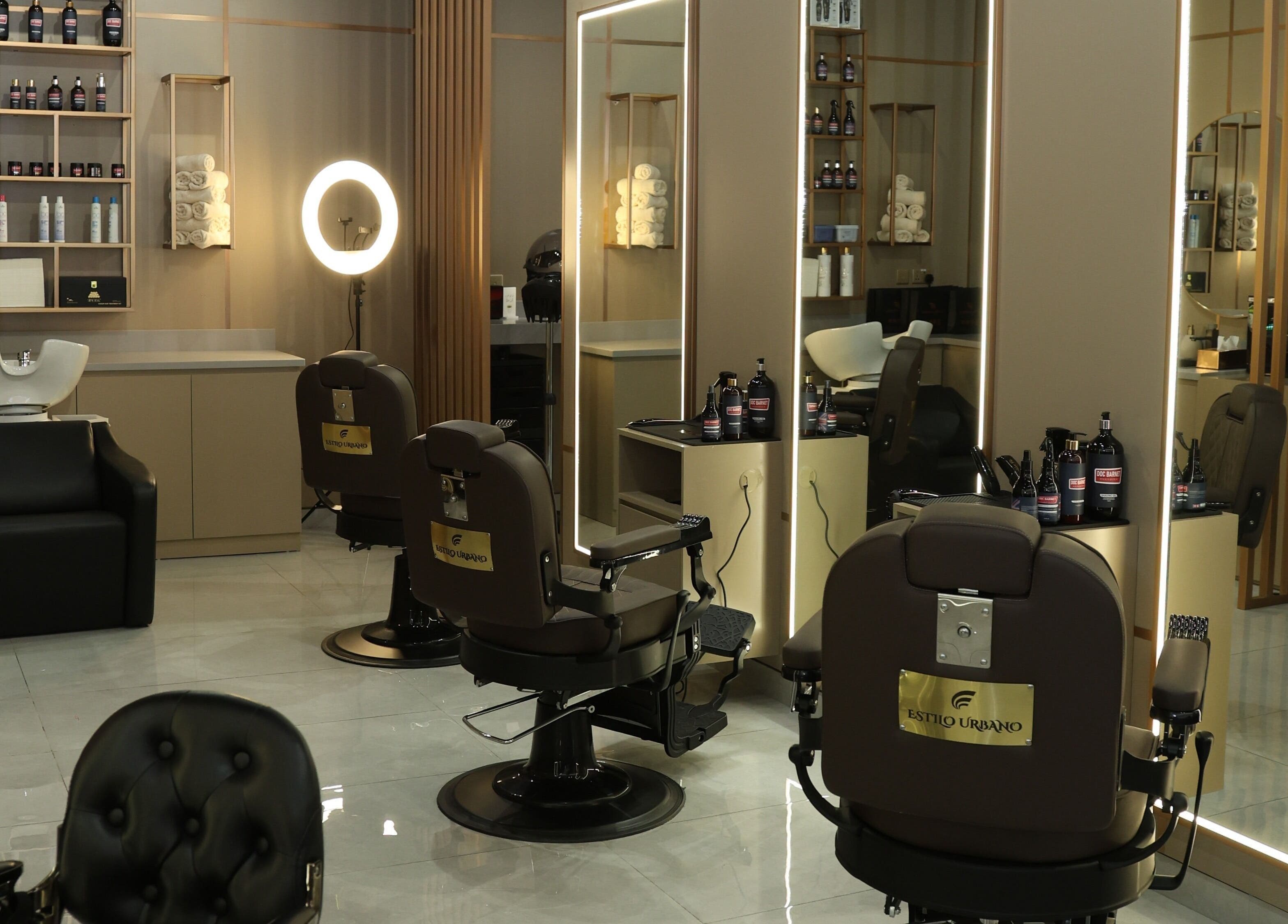 Stylish interior of Estilo Urbano Gents Salon in Umm Al Quwain, featuring sleek chairs and products.