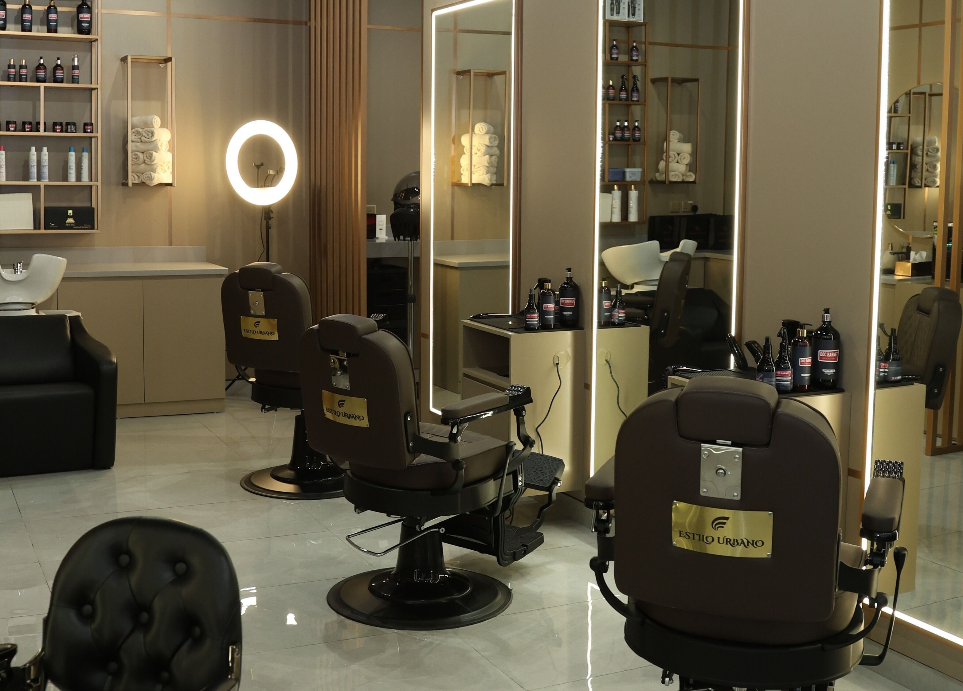 Stylish interior of Estilo Urbano Gents Salon in Umm Al Quwain, featuring sleek chairs and products.
