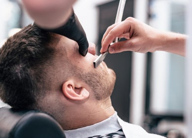 Expert barber performing precision shave at Twenty.Two Cut & Facial Premium Barbershop in Krung Thep Maha Nakhon, TH.