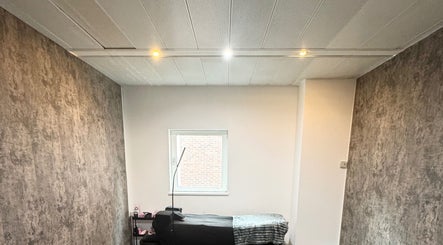 A cozy treatment room at The Blink Atelier LDN in London, England, GB featuring a massage bed and calming decor.