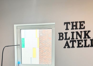The Blink Atelier LDN logo on a wall next to a bright window in London, England, GB.