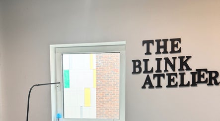 The Blink Atelier LDN logo on a wall next to a bright window in London, England, GB.