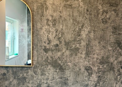 Modern arched mirror on textured wall at The Blink Atelier LDN, London, England, GB.
