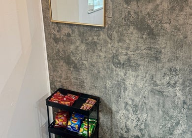 Cozy snack corner at The Blink Atelier LDN, London, England, GB with a rustic wall and snack-filled cart.