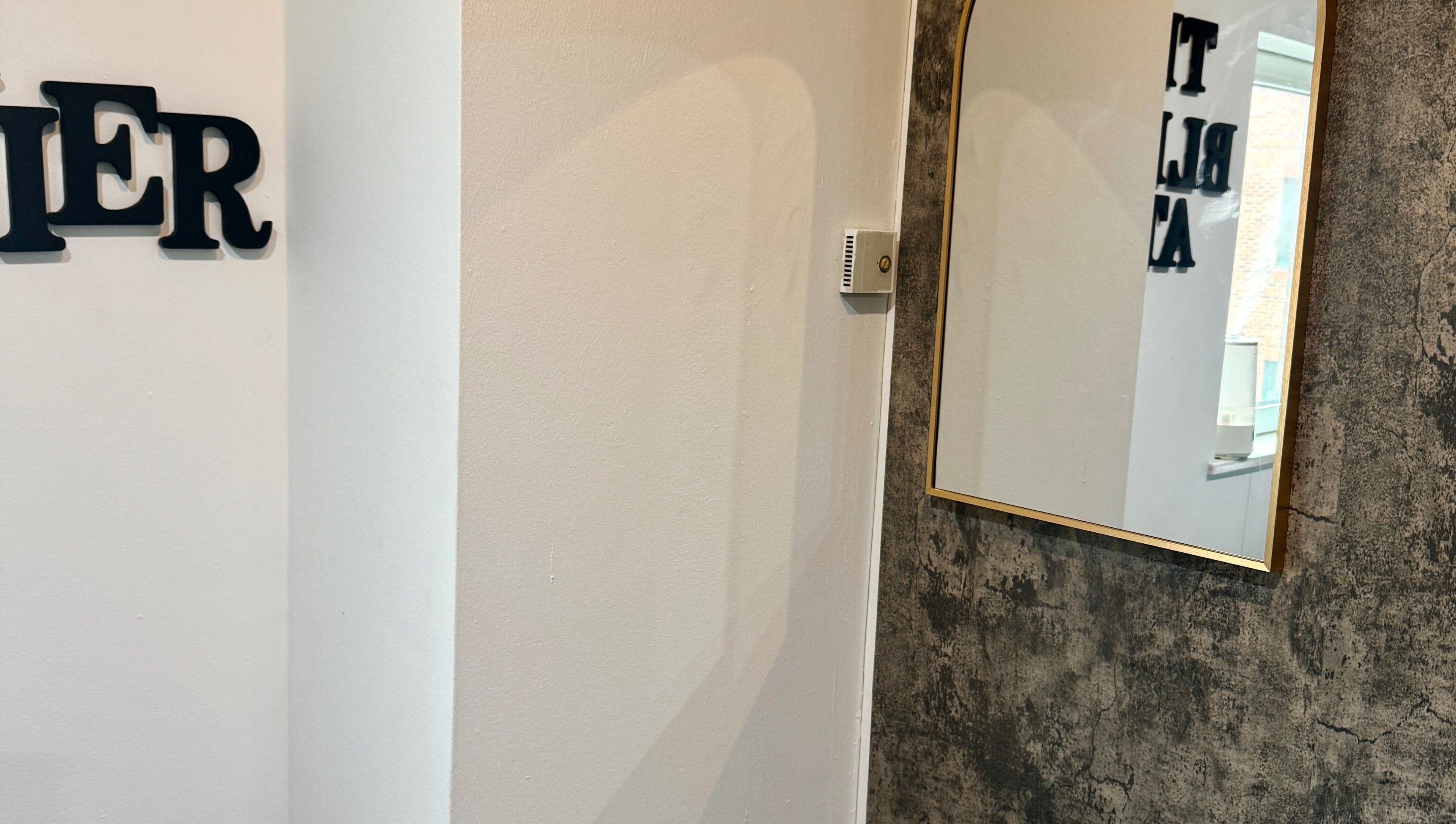 Elegant mirror on a textured wall at The Blink Atelier LDN, London, England, GB.